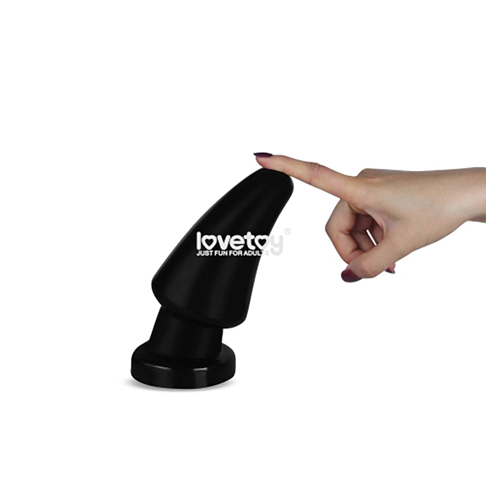 King Sized Anal Shocker 2 svart XXL analplugg från Chambers of Love med LoveToy-logotyp – finger trycker på spetsen för att visa flexibilitet och böjlig PVC-yta
